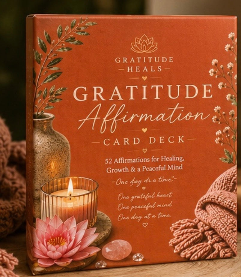 Gratitude Affirmation Card Deck box with a terracotta orange cover, decorated with a pink lotus flower, candle, crystals, and knitted fabric. The box features the text 'Gratitude Heals' and 'Gratitude Affirmation Card Deck' in white and gold lettering.